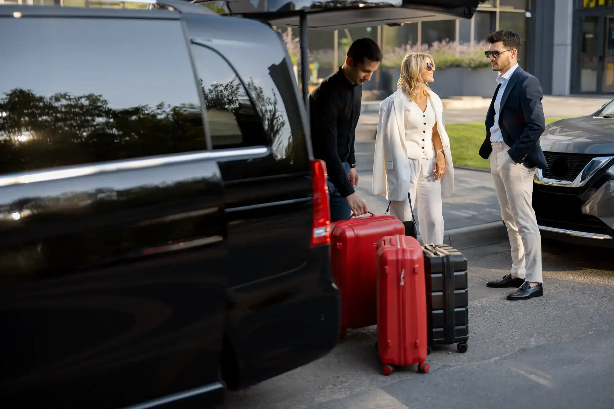 Luxury black sedan waiting curbside at Philadelphia airport, chauffeur in uniform opening door for passenger, clear signage in background, representing premium airport car service