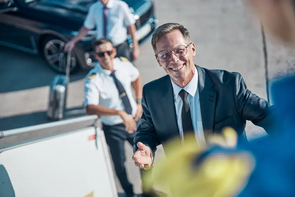 Businessmen smiling as they board their flight at Philadelphia airport, ready for their next corporate trip with Philadelphia Car and Limo services