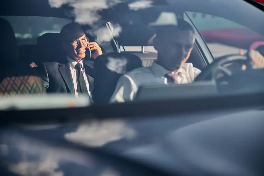 A businessman engaged in a conversation inside a luxury car in Philadelphia County, Pennsylvania, showcasing professional transportation services from Philadelphia Car and Limo