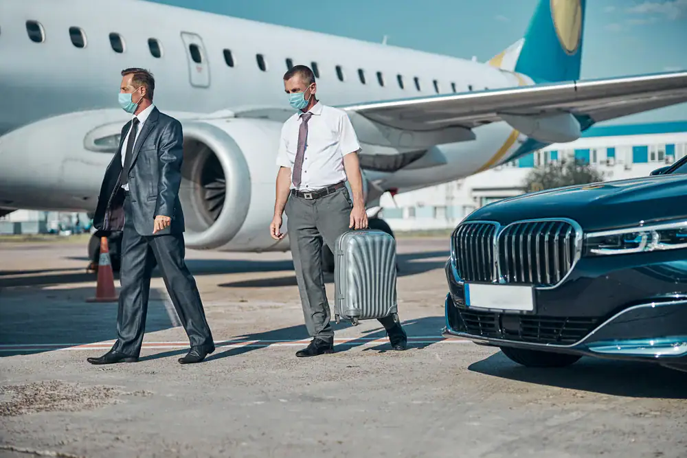 Professional men at Philadelphia Airport, greeted by a sleek limo for a seamless airport arrival with Philadelphia Car and Limo service in Philadelphia County, PA